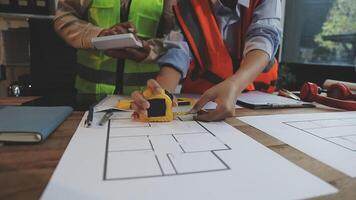 Two people working on a blueprint with a ruler video