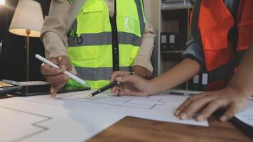 Two people in safety vests working on a blueprint video