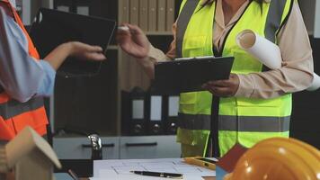 Two construction workers are talking on a tablet video