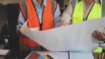 Two people in safety vests looking at a blueprint video