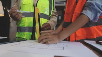 Two people in safety vests working on a blueprint video