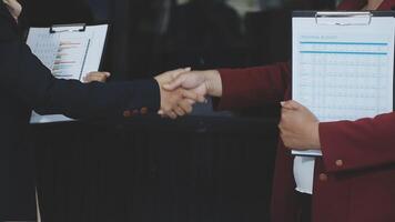 Two business people shaking hands with a clipboard video