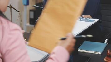 A woman is holding a folder while sitting at a desk video