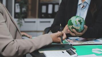 Business people working on a project with a globe video