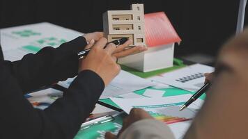 Two people are holding a model of a house video