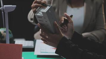 A person is holding a piece of paper and a computer video