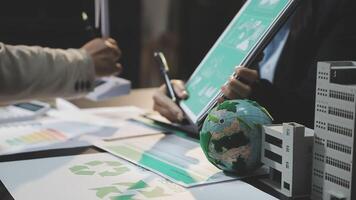 Business people working on a project with recycling and green paper video