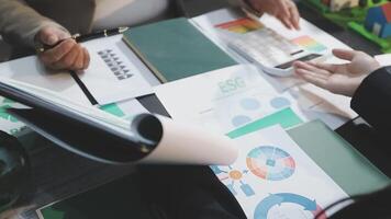 Business people working on a table with papers and graphs video