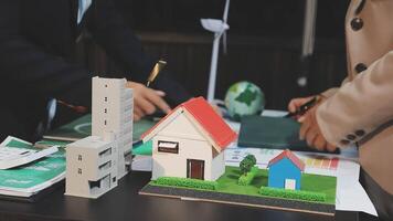 Two people are working on a model of a house video