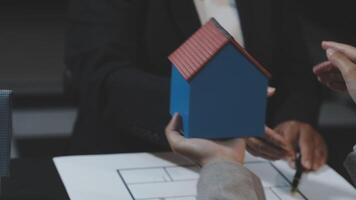 Two people holding a house model and a piece of paper video