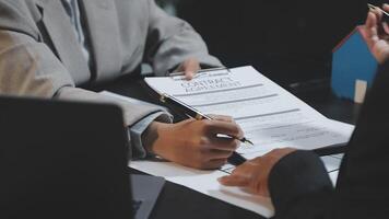 A businessperson signing a contract with another person video