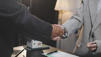 Two business people shaking hands over a desk video