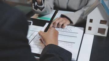 A real estate agent is signing a contract with a client video