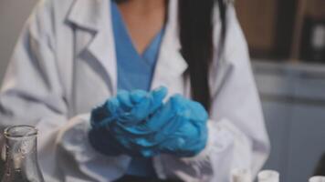 A woman in a lab coat is holding a vial video