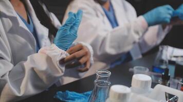 Two women in lab coats and gloves working on a project video