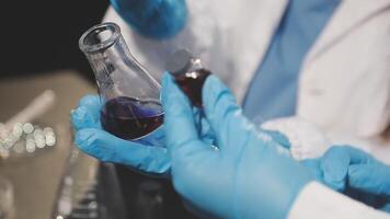 A person in a lab coat holding a test tube video