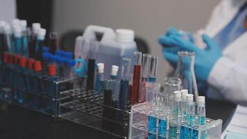 A person in a lab coat is working on a test tube video