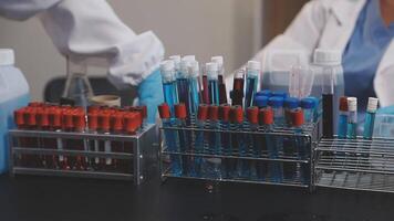 Two people in lab coats are working on a table video
