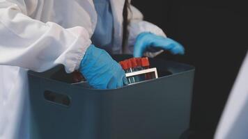 A person in a lab coat is holding a container with a pair of gloves video