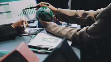Business people working on a computer with a globe video