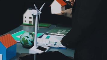 A man in a suit is holding a wind turbine video