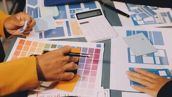 A group of people working on a project with colorful papers video