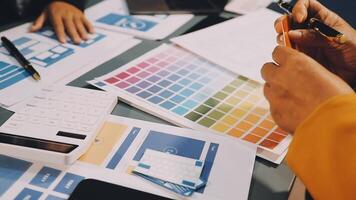 A person is working on a computer with a pen and a color chart video