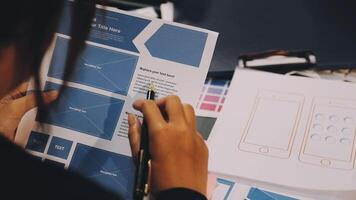 A person is working on a design project with a laptop video