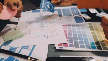People working on a design project with various colors and papers video