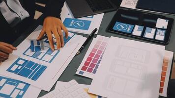A person is working on a design project with a laptop and a tablet video