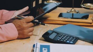 A man using a tablet and calculator at a desk video