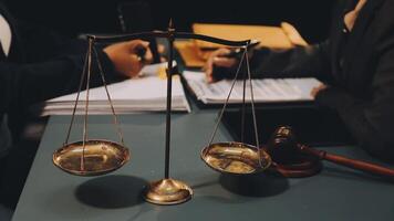 Lawyer and judge sitting at a desk with scales of justice video