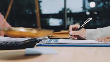 Two people are sitting at a table with a pen and paper video