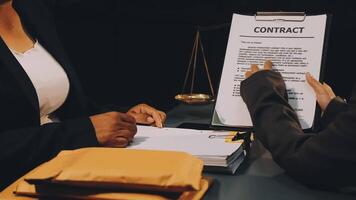 Two business people sitting at a table with a contract video
