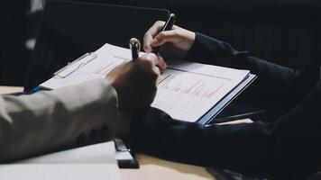 Two people are working on a document with a pen and paper video