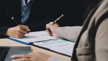 Two business people are working on paperwork at a desk video