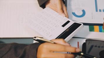 A person is using a calculator to calculate the cost of a business video