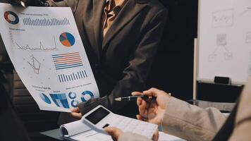 Business people looking at graphs and charts on a whiteboard video