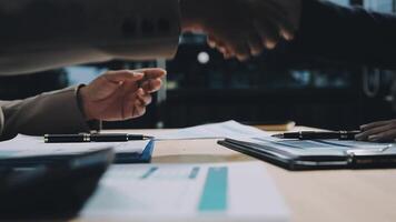 Two business people shaking hands over a desk video