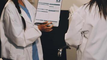 Two women in white lab coats are talking to each other video