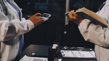 Two doctors are talking on a phone while holding a clipboard video