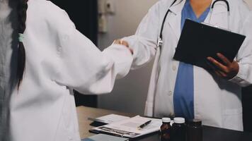 Two doctors shaking hands in front of a desk video