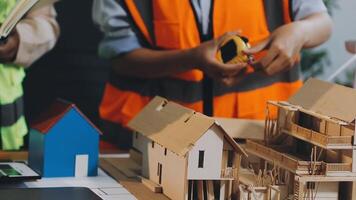 Two people working on a model of a house video