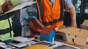 Two construction workers working on a model of a house video