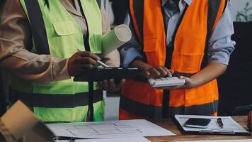 Two construction workers in safety vests working on a project video
