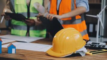 Two people in hard hats and vests are working on a project video