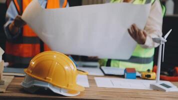 Two people in hard hats and safety vests are working on a construction project video