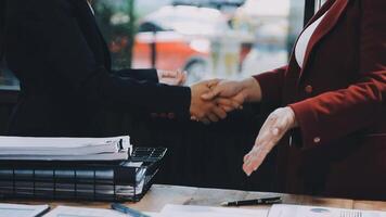 Two business people shaking hands over a desk video
