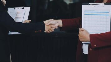 Two business people shaking hands with a clipboard video