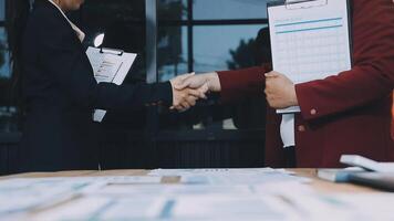 Two business people shaking hands over a table video